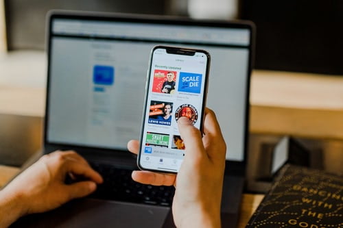 Person using smartphone and laptop at the same time